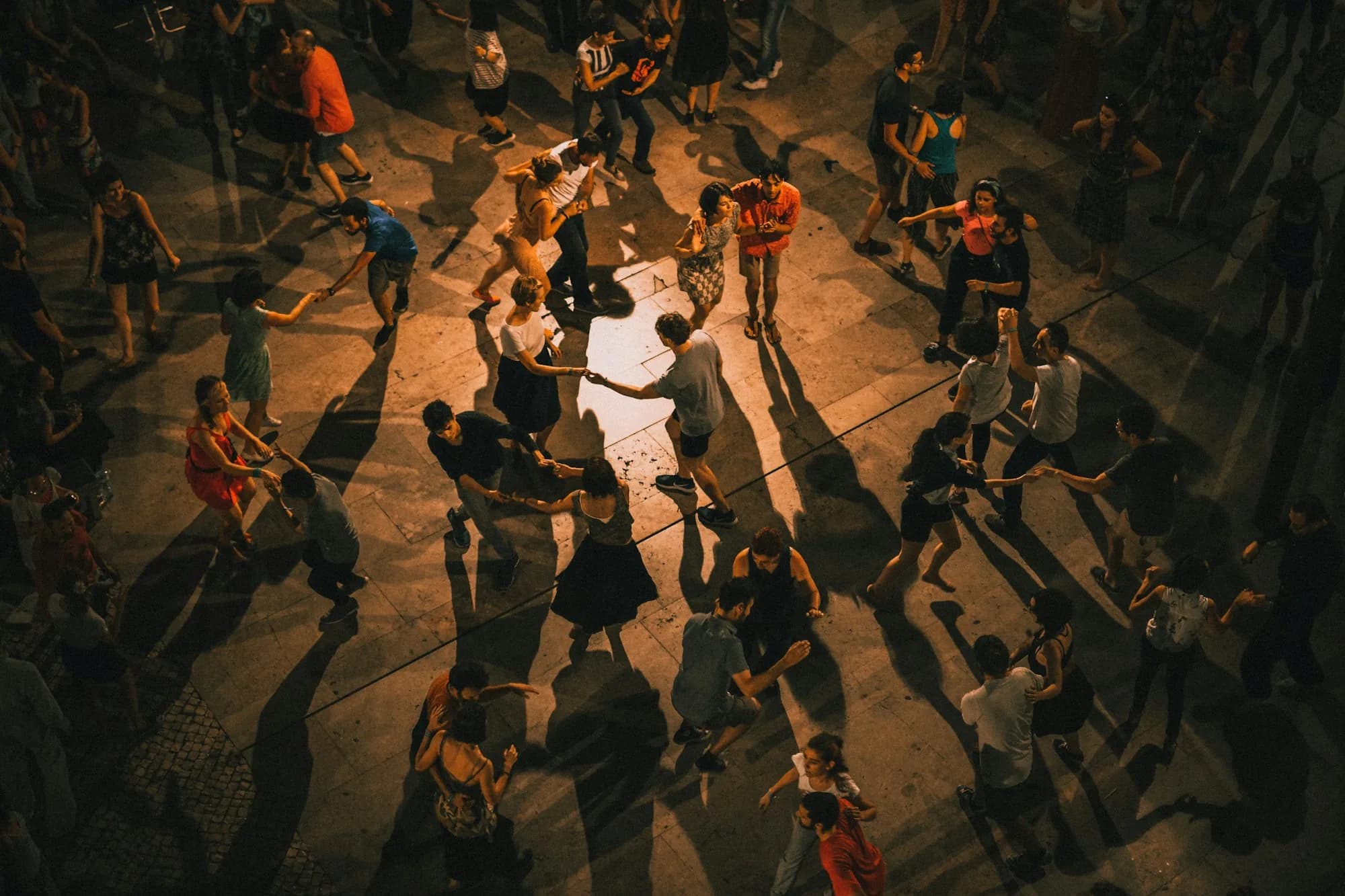 Vue en plongée d'une piste de danse animée, éclairée en lumière chaude