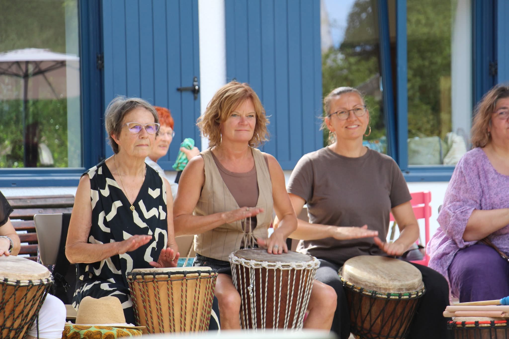 Trois participantes d'AKOFA ASBL, percussions en gros plan