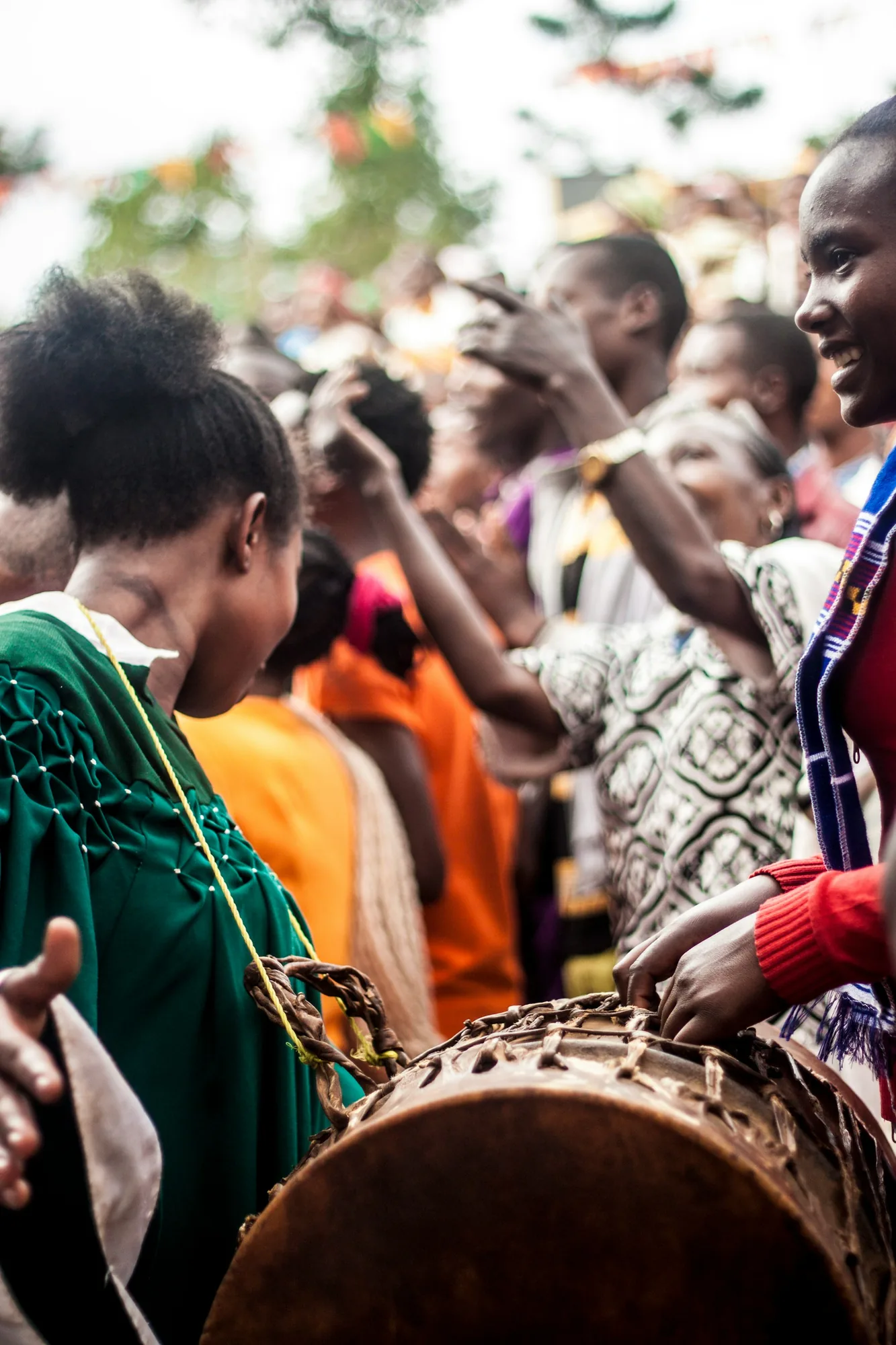 Cercle de percussions au milieu d'une foule, mains sur un tambour