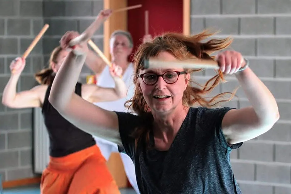 Une participante à un cours de danse africaine en train d'executer un geste de percussion